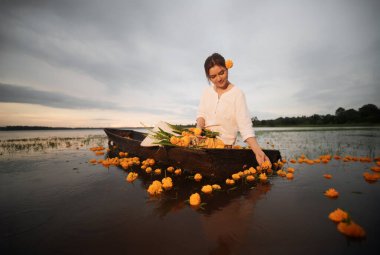 Nehirde çiçekleri olan güzel bir kadın.