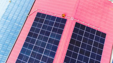 Teknoloji güneş pili, mühendislik hizmeti kurulum güneş pili fabrika endüstrisinin çatısında. Fabrikanın çatısındaki güneş pilini inceleyen teknisyen. 