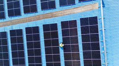 Teknoloji güneş pili, mühendislik hizmeti kurulum güneş pili fabrika endüstrisinin çatısında. Fabrikanın çatısındaki güneş pilini inceleyen teknisyen. 