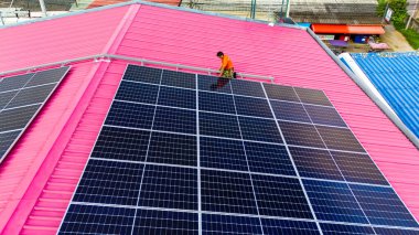 Teknoloji güneş pili, mühendislik hizmeti kurulum güneş pili fabrika endüstrisinin çatısında. Fabrikanın çatısındaki güneş pilini inceleyen teknisyen. 