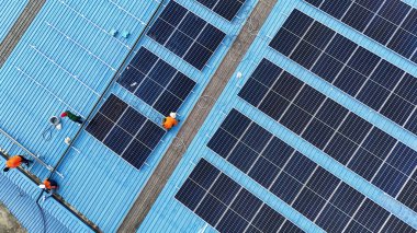 Hava manzarası, güneş panelleri büyük bir binanın çatısına kurulmuş. Güneş pili çiftliği enerji santrali eko teknolojisi. Bir fotovoltaik enerji santralindeki güneş pili panellerinin peyzajı