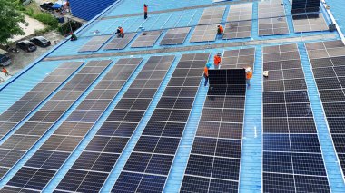 Hava manzarası, güneş panelleri büyük bir binanın çatısına kurulmuş. Güneş pili çiftliği enerji santrali eko teknolojisi. Bir fotovoltaik enerji santralindeki güneş pili panellerinin peyzajı