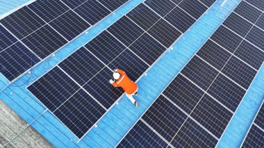 Teknoloji güneş pili, mühendislik hizmeti kurulum güneş pili fabrika endüstrisinin çatısında. Fabrikanın çatısındaki güneş pilini inceleyen teknisyen. 