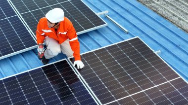 Teknoloji güneş pili, mühendislik hizmeti kurulum güneş pili fabrika endüstrisinin çatısında. Fabrikanın çatısındaki güneş pilini inceleyen teknisyen. 