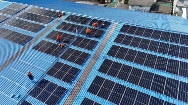 Hava manzarası, güneş panelleri büyük bir binanın çatısına kurulmuş. Güneş pili çiftliği enerji santrali eko teknolojisi. Bir fotovoltaik enerji santralindeki güneş pili panellerinin peyzajı