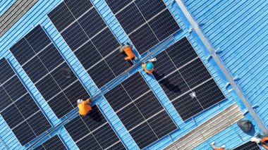 Hava manzarası, güneş panelleri büyük bir binanın çatısına kurulmuş. Güneş pili çiftliği enerji santrali eko teknolojisi. Bir fotovoltaik enerji santralindeki güneş pili panellerinin peyzajı