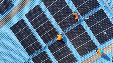 Hava manzarası, güneş panelleri büyük bir binanın çatısına kurulmuş. Güneş pili çiftliği enerji santrali eko teknolojisi. Bir fotovoltaik enerji santralindeki güneş pili panellerinin peyzajı