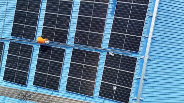 Hava manzarası, güneş panelleri büyük bir binanın çatısına kurulmuş. Güneş pili çiftliği enerji santrali eko teknolojisi. Bir fotovoltaik enerji santralindeki güneş pili panellerinin peyzajı