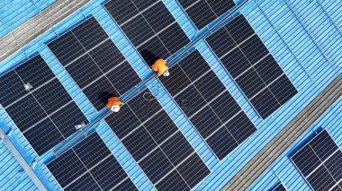 Hava manzarası, güneş panelleri büyük bir binanın çatısına kurulmuş. Güneş pili çiftliği enerji santrali eko teknolojisi. Bir fotovoltaik enerji santralindeki güneş pili panellerinin peyzajı