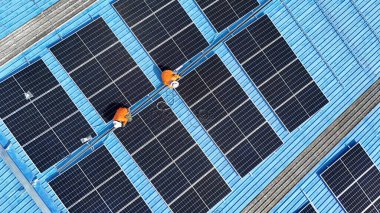 Hava manzarası, güneş panelleri büyük bir binanın çatısına kurulmuş. Güneş pili çiftliği enerji santrali eko teknolojisi. Bir fotovoltaik enerji santralindeki güneş pili panellerinin peyzajı