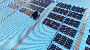 Hava manzarası, güneş panelleri büyük bir binanın çatısına kurulmuş. Güneş pili çiftliği enerji santrali eko teknolojisi. Bir fotovoltaik enerji santralindeki güneş pili panellerinin peyzajı