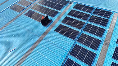 Hava manzarası, güneş panelleri büyük bir binanın çatısına kurulmuş. Güneş pili çiftliği enerji santrali eko teknolojisi. Bir fotovoltaik enerji santralindeki güneş pili panellerinin peyzajı