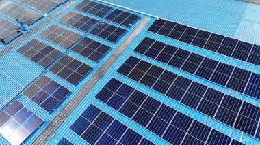 Hava manzarası, güneş panelleri büyük bir binanın çatısına kurulmuş. Güneş pili çiftliği enerji santrali eko teknolojisi. Bir fotovoltaik enerji santralindeki güneş pili panellerinin peyzajı