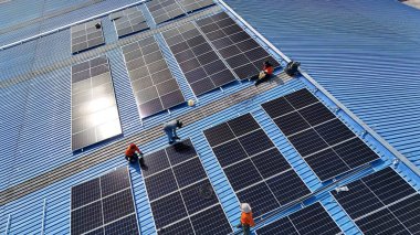 Hava manzarası, güneş panelleri büyük bir binanın çatısına kurulmuş. Güneş pili çiftliği enerji santrali eko teknolojisi. Bir fotovoltaik enerji santralindeki güneş pili panellerinin peyzajı