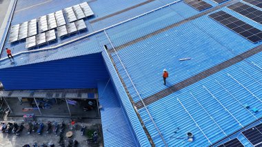 Hava manzarası, güneş panelleri büyük bir binanın çatısına kurulmuş. Güneş pili çiftliği enerji santrali eko teknolojisi. Bir fotovoltaik enerji santralindeki güneş pili panellerinin peyzajı