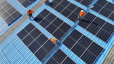 Hava manzarası, güneş panelleri büyük bir binanın çatısına kurulmuş. Güneş pili çiftliği enerji santrali eko teknolojisi. Bir fotovoltaik enerji santralindeki güneş pili panellerinin peyzajı