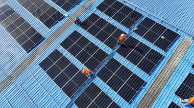 Hava manzarası, güneş panelleri büyük bir binanın çatısına kurulmuş. Güneş pili çiftliği enerji santrali eko teknolojisi. Bir fotovoltaik enerji santralindeki güneş pili panellerinin peyzajı