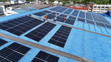 Hava manzarası, güneş panelleri büyük bir binanın çatısına kurulmuş. Güneş pili çiftliği enerji santrali eko teknolojisi. Bir fotovoltaik enerji santralindeki güneş pili panellerinin peyzajı