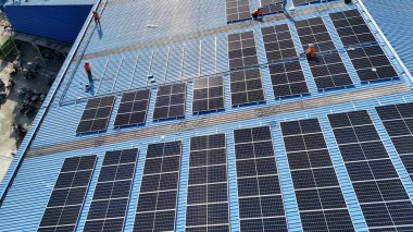Hava manzarası, güneş panelleri büyük bir binanın çatısına kurulmuş. Güneş pili çiftliği enerji santrali eko teknolojisi. Bir fotovoltaik enerji santralindeki güneş pili panellerinin peyzajı