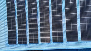 Hava manzarası, güneş panelleri büyük bir binanın çatısına kurulmuş. Güneş pili çiftliği enerji santrali eko teknolojisi. Bir fotovoltaik enerji santralindeki güneş pili panellerinin peyzajı