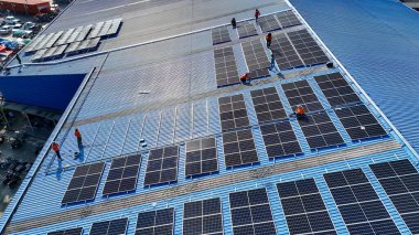 Hava manzarası, güneş panelleri büyük bir binanın çatısına kurulmuş. Güneş pili çiftliği enerji santrali eko teknolojisi. Bir fotovoltaik enerji santralindeki güneş pili panellerinin peyzajı