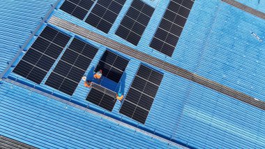 Hava manzarası, güneş panelleri büyük bir binanın çatısına kurulmuş. Güneş pili çiftliği enerji santrali eko teknolojisi. Bir fotovoltaik enerji santralindeki güneş pili panellerinin peyzajı