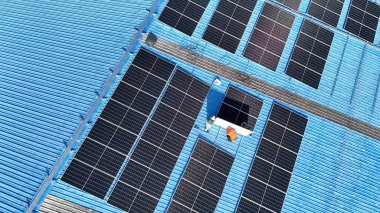 Hava manzarası, güneş panelleri büyük bir binanın çatısına kurulmuş. Güneş pili çiftliği enerji santrali eko teknolojisi. Bir fotovoltaik enerji santralindeki güneş pili panellerinin peyzajı