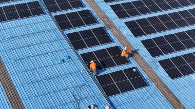 Hava manzarası, güneş panelleri büyük bir binanın çatısına kurulmuş. Güneş pili çiftliği enerji santrali eko teknolojisi. Bir fotovoltaik enerji santralindeki güneş pili panellerinin peyzajı