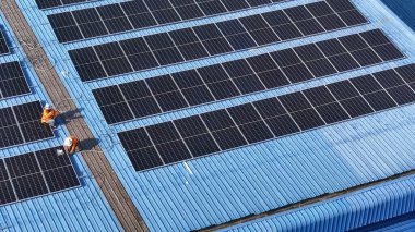 Hava manzarası, güneş panelleri büyük bir binanın çatısına kurulmuş. Güneş pili çiftliği enerji santrali eko teknolojisi. Bir fotovoltaik enerji santralindeki güneş pili panellerinin peyzajı