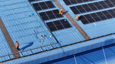 Hava manzarası, güneş panelleri büyük bir binanın çatısına kurulmuş. Güneş pili çiftliği enerji santrali eko teknolojisi. Bir fotovoltaik enerji santralindeki güneş pili panellerinin peyzajı