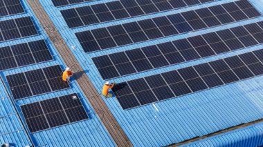 Hava manzarası, güneş panelleri büyük bir binanın çatısına kurulmuş. Güneş pili çiftliği enerji santrali eko teknolojisi. Bir fotovoltaik enerji santralindeki güneş pili panellerinin peyzajı
