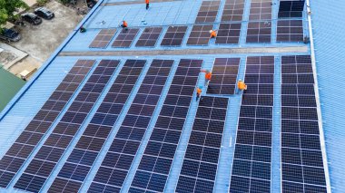 Hava manzarası, güneş panelleri büyük bir binanın çatısına kurulmuş. Güneş pili çiftliği enerji santrali eko teknolojisi. Bir fotovoltaik enerji santralindeki güneş pili panellerinin peyzajı