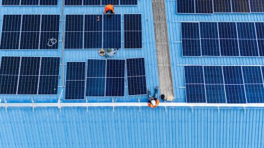 Hava manzarası, güneş panelleri büyük bir binanın çatısına kurulmuş. Güneş pili çiftliği enerji santrali eko teknolojisi. Bir fotovoltaik enerji santralindeki güneş pili panellerinin peyzajı