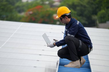 Çatıda dizüstü bilgisayarda çalışan Asyalı mühendis..