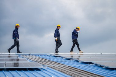 Erkek teknisyenler fotovoltaik güneş modüllerini evin çatısına monte ediyorlar. Yenilenebilir Enerji Eko Teknolojisi.