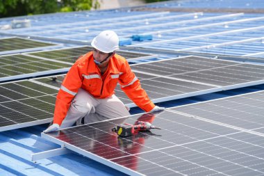 Teknoloji güneş pili, mühendislik hizmeti kurulum güneş pili fabrika endüstrisinin çatısında. Fabrikanın çatısındaki güneş pilini inceleyen teknisyen. 