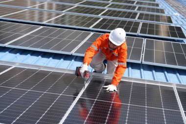 Teknoloji güneş pili, mühendislik hizmeti kurulum güneş pili fabrika endüstrisinin çatısında. Fabrikanın çatısındaki güneş pilini inceleyen teknisyen. 