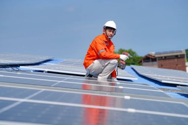 Teknoloji güneş pili, mühendislik hizmeti kurulum güneş pili fabrika endüstrisinin çatısında. Fabrikanın çatısındaki güneş pilini inceleyen teknisyen. 