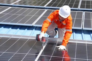 Teknoloji güneş pili, mühendislik hizmeti kurulum güneş pili fabrika endüstrisinin çatısında. Fabrikanın çatısındaki güneş pilini inceleyen teknisyen. 