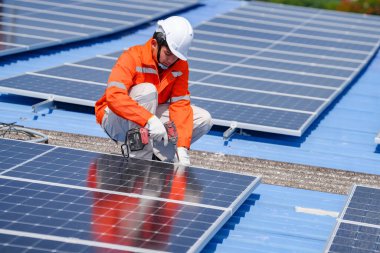 Teknoloji güneş pili, mühendislik hizmeti kurulum güneş pili fabrika endüstrisinin çatısında. Fabrikanın çatısındaki güneş pilini inceleyen teknisyen. 