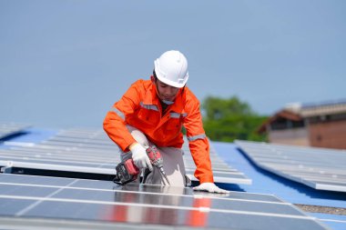 Teknoloji güneş pili, mühendislik hizmeti kurulum güneş pili fabrika endüstrisinin çatısında. Fabrikanın çatısındaki güneş pilini inceleyen teknisyen. 