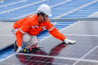 Teknoloji güneş pili, mühendislik hizmeti kurulum güneş pili fabrika endüstrisinin çatısında. Fabrikanın çatısındaki güneş pilini inceleyen teknisyen. 