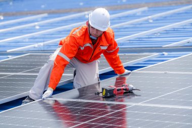 Teknoloji güneş pili, mühendislik hizmeti kurulum güneş pili fabrika endüstrisinin çatısında. Fabrikanın çatısındaki güneş pilini inceleyen teknisyen. 