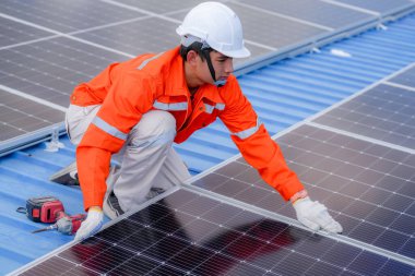 Teknoloji güneş pili, mühendislik hizmeti kurulum güneş pili fabrika endüstrisinin çatısında. Fabrikanın çatısındaki güneş pilini inceleyen teknisyen. 