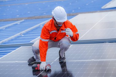 Teknoloji güneş pili, mühendislik hizmeti kurulum güneş pili fabrika endüstrisinin çatısında. Fabrikanın çatısındaki güneş pilini inceleyen teknisyen. 