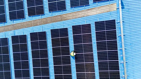 Teknoloji güneş pili, mühendislik hizmeti kurulum güneş pili fabrika endüstrisinin çatısında. Fabrikanın çatısındaki güneş pilini inceleyen teknisyen. 