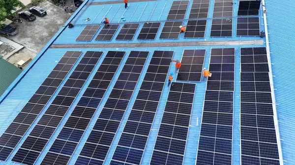 Hava manzarası, güneş panelleri büyük bir binanın çatısına kurulmuş. Güneş pili çiftliği enerji santrali eko teknolojisi. Bir fotovoltaik enerji santralindeki güneş pili panellerinin peyzajı