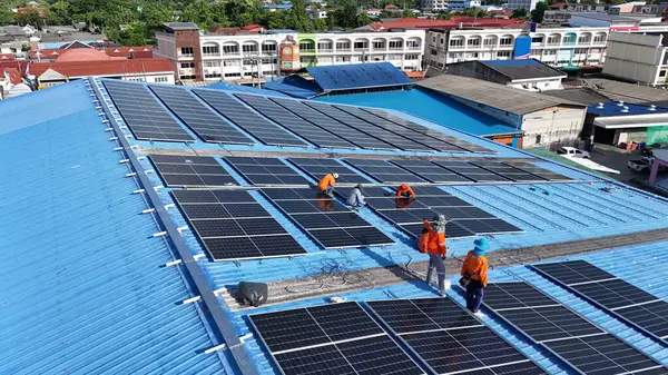 Hava manzarası, güneş panelleri büyük bir binanın çatısına kurulmuş. Güneş pili çiftliği enerji santrali eko teknolojisi. Bir fotovoltaik enerji santralindeki güneş pili panellerinin peyzajı