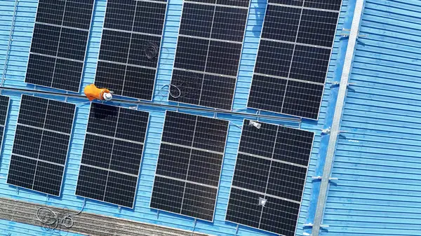 Hava manzarası, güneş panelleri büyük bir binanın çatısına kurulmuş. Güneş pili çiftliği enerji santrali eko teknolojisi. Bir fotovoltaik enerji santralindeki güneş pili panellerinin peyzajı