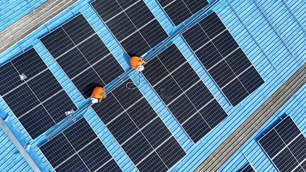 Hava manzarası, güneş panelleri büyük bir binanın çatısına kurulmuş. Güneş pili çiftliği enerji santrali eko teknolojisi. Bir fotovoltaik enerji santralindeki güneş pili panellerinin peyzajı